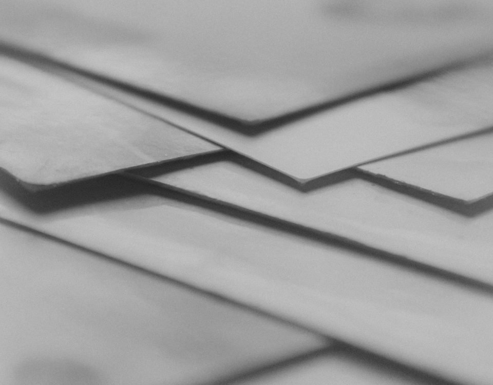 Close-up of overlapping paper layers in grayscale, creating an abstract artistic effect.